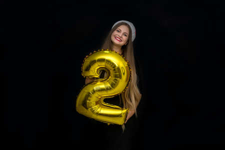 Beautiful woman with air balloon number 2 isolated on blackの写真素材