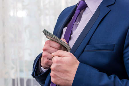 Side view of businessman holding euro and dollar bundleの写真素材