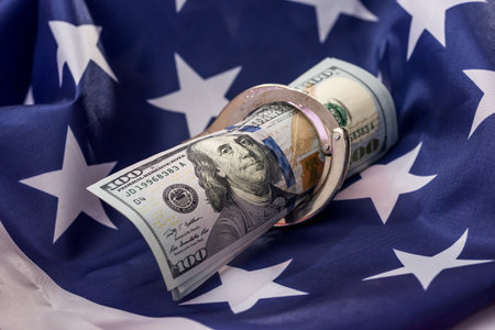 American dollars in handcuffs on national flagの写真素材