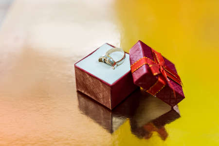 Wedding rings in red present box on golden backgroundの写真素材