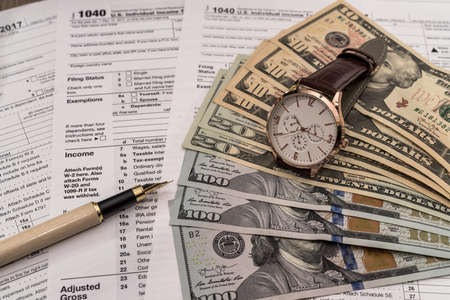 Dollar banknotes on 1040 tax form with penの写真素材
