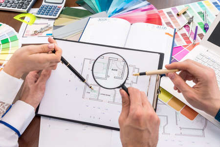 Team of creative designers discussing house plan in office