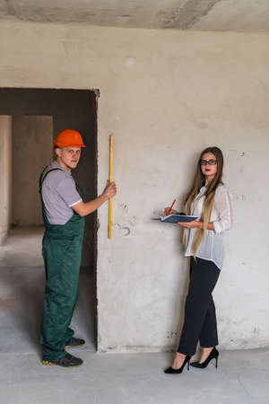 Worker with level tool and beautiful womanの写真素材