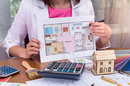 Female hands showing house plan in office