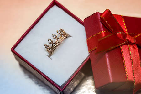Red gift box with golden ring like crownの写真素材