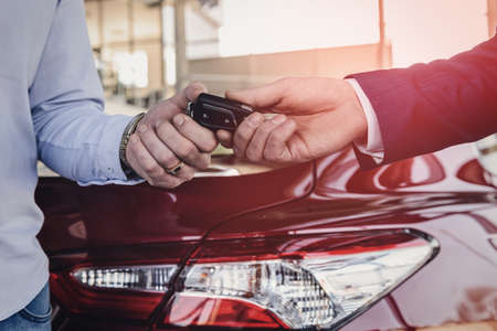 Dealer giving keys from new car to customer closeupの写真素材