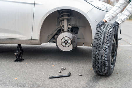 Worker hands with spare wheel, close upの写真素材