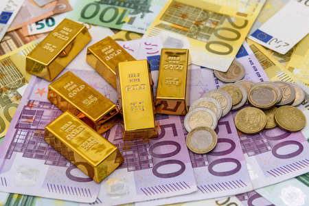 Bullion with euro cent coins at euro banknote backgroundの写真素材