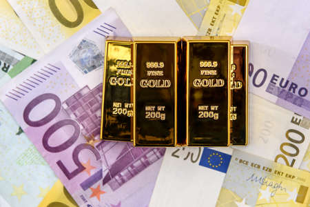 Gold bullions at euro banknotes background closeupの写真素材