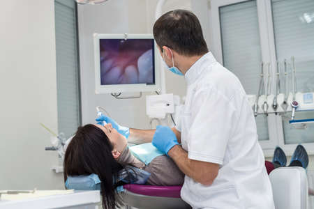 Patient and dentist looking at screen in dentistryの写真素材