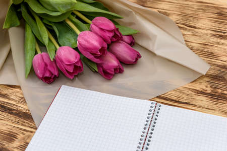 Open blank notepad and bouquet of pink tulip flowersの写真素材