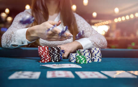 Female hands with playing cards and poker chips