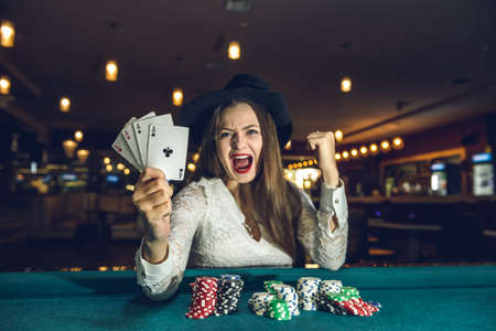 Happy woman in casino holding four acesの写真素材