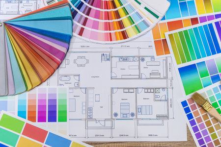 Close up of wooden house model with blueprint and color swatches