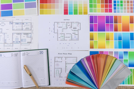 Diary with pen and color swatch on house plan in office