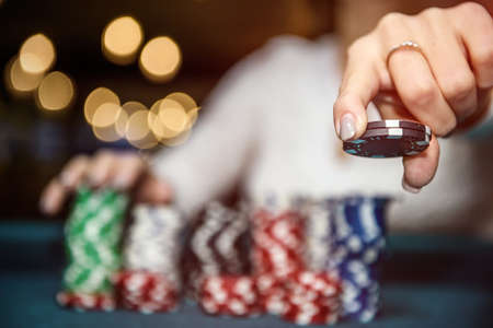 Female hands with piles of poker chips closeup
