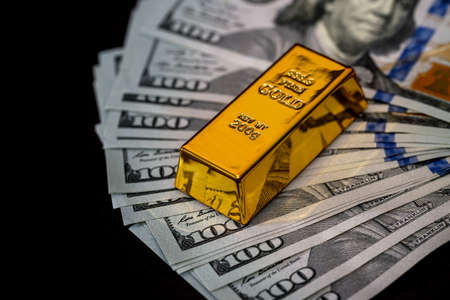 Dollar banknotes on black background with gold bullion