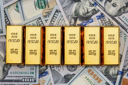 Gold bullion on american dollar banknotes close upの写真素材