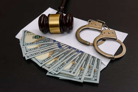 Dollars in envelope, handcuffs and judge's gavelの写真素材