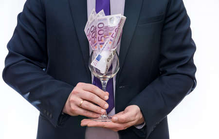 Wine glass with euro banknotes in male handsの写真素材
