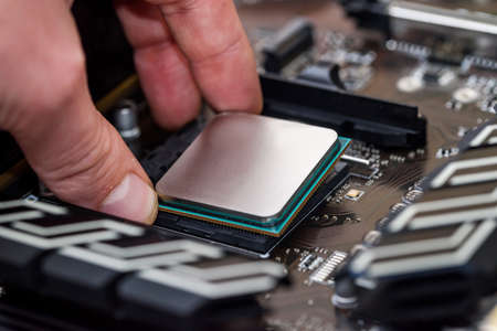 Human hand taking out cpu from motherboard
