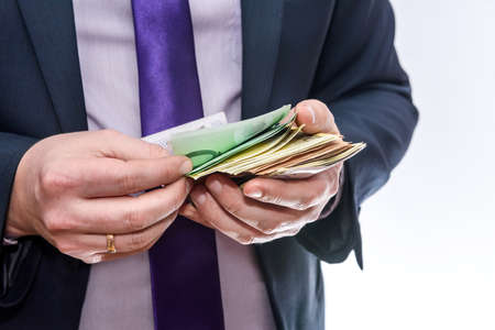 Man in suit offering euro banknotes close upの写真素材