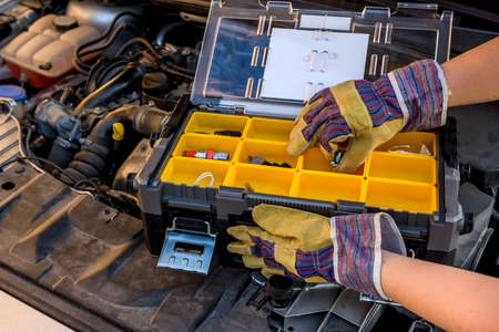 Tool box with hand on car engine close upの写真素材