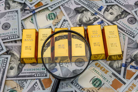 Bullion, gold or ingot on US dollar banknote with magnifier