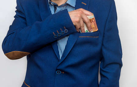 Hands of businessman hiding euro into pocket