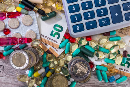 Colorful pills on euro banknotes with calculator