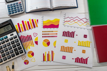 Business analyst's workplace with graphs, calculator and laptopの写真素材