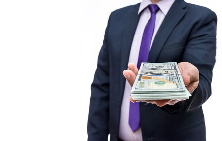Man in business suit holds one hundred dollar denominationsの写真素材