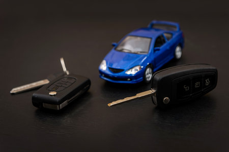 Blue toy car with keys on dark backgroundの写真素材