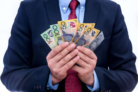 Male hand offering australian dollar banknotes isolated on whiteの写真素材