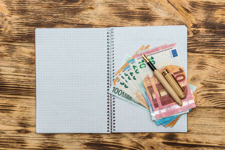 Euro banknotes with pen on empty notepad