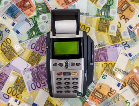 Banking terminal on euro banknotes background close upの写真素材