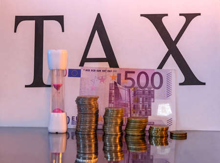 Euro cents and banknotes with word tax and reflectionの写真素材