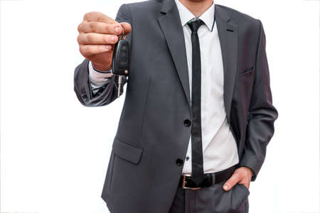 Male hand with car key close up isolated on whiteの写真素材