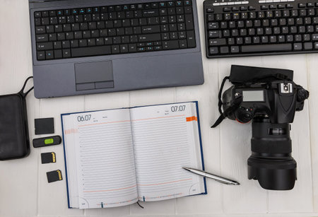 Workplace with laptop and digital camera top view