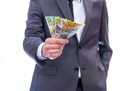 Businessman showing fan of australian dollar banknotesの写真素材