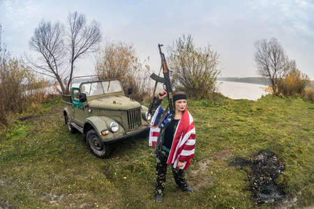 Woman with rifle and usa flag on shoulders