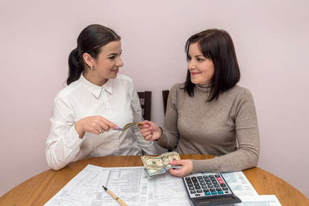 Women with dollar banknotes and 1040 tax form