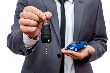 Man holding toy car and keys isolated on whiteの写真素材