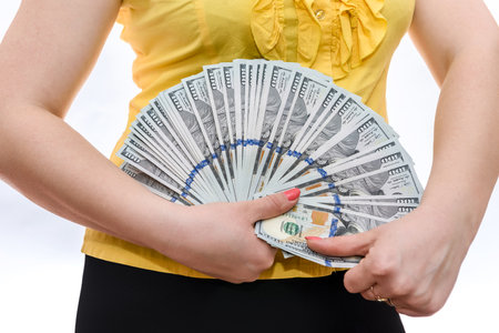 Female hands holding dollar banknotes in fanの写真素材