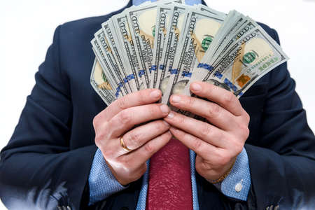 Man in suit holding dollar banknotes close up