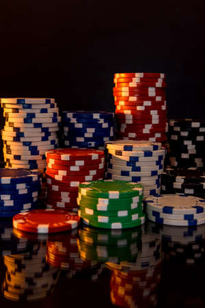Colorful poker chips on reflecting surface close upの写真素材