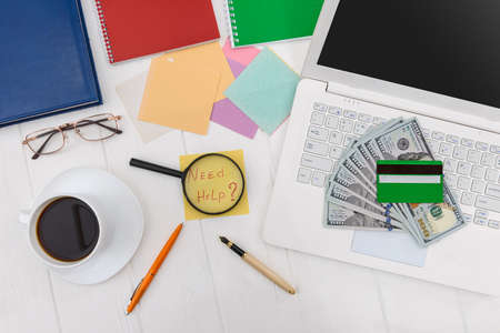 Dollars with credit card and magnifier on laptop keyboardの写真素材