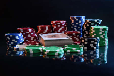 Pile of playing cards with colorful poker chipsの写真素材