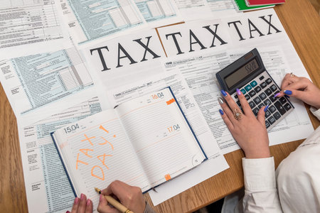 Female hands with pen and calculator on 1040 formの写真素材