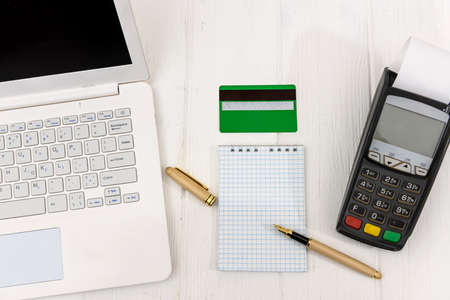 Empty notepad with terminal, credit card and laptop